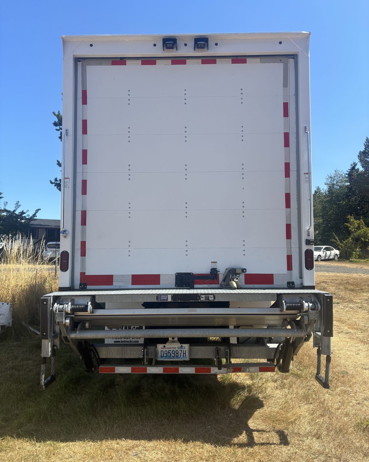 Rear of the truck with the hydraulic lift gate folded against the roll-up door